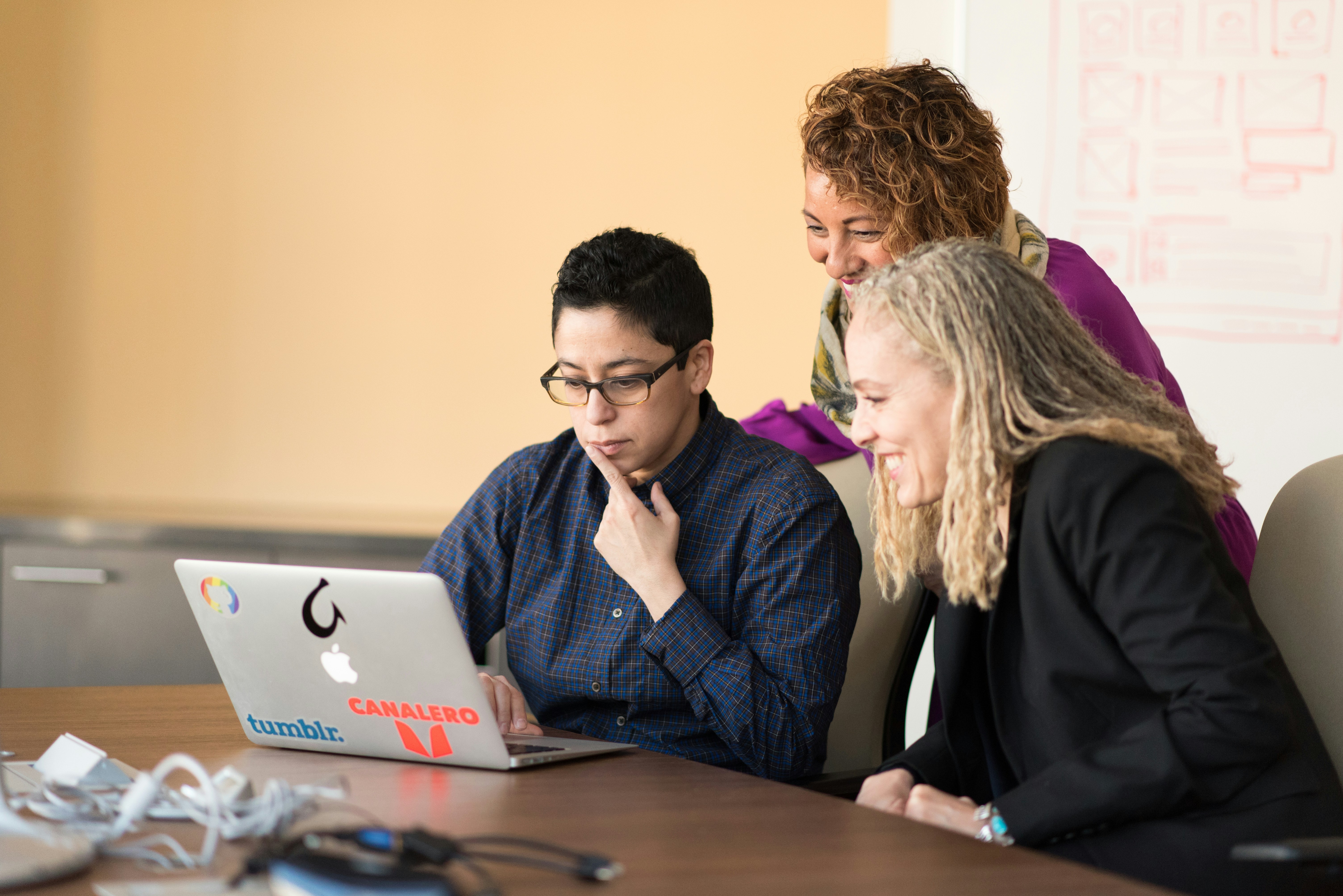 Three People Looking at a Laptop - Omnichannel Marketing Strategy